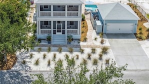 A two-story house with a large balcony, a swimming pool, and a view of the ocean. - Relax in Style at your Private Pool & Hot Tub w Beach, Food & Drinks Nearby (Port St. Joe)