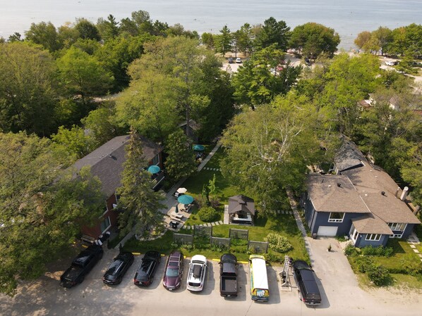 Vista aérea de una zona residencial con un estacionamiento, casas y una playa al fondo.