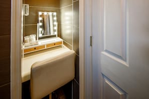 Ein Badezimmer-Waschtisch mit Spiegel, Beleuchtung und Handtuchhalter.