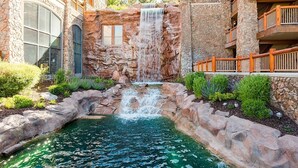 A hotel with a natural rock waterfall, a swimming pool, and a stone facade. - Labor Day Sale - Limited Time Offer, Save up to 30% (Park City)