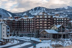 A multi-story hotel with balconies, a ski resort in the background, and a snow-covered landscape. - Westgate 3303A (Park City)