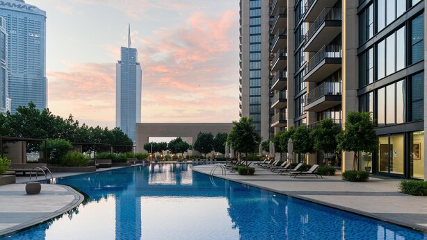 A modern hotel with a swimming pool, surrounded by lush greenery and high-rise buildings. - Dream Inn Apartment- Boulevard Heights (Dubai)