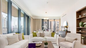 A modern living room with a sofa set, a coffee table with a plant, and a bookshelf. - Dream Inn Apartment- Boulevard Heights (Dubai)