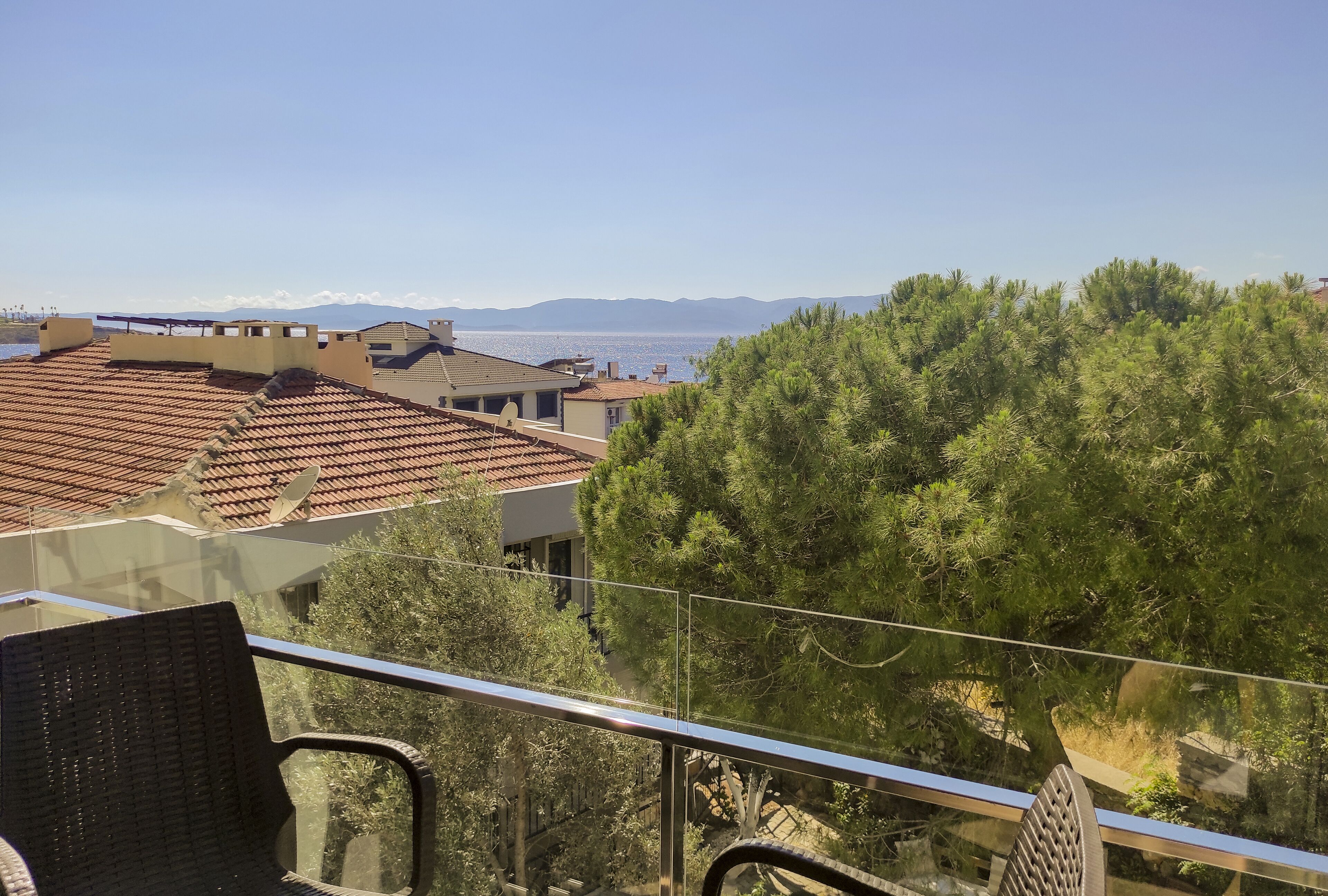 Un balcón con vistas a la costa, incluyendo edificios y árboles.