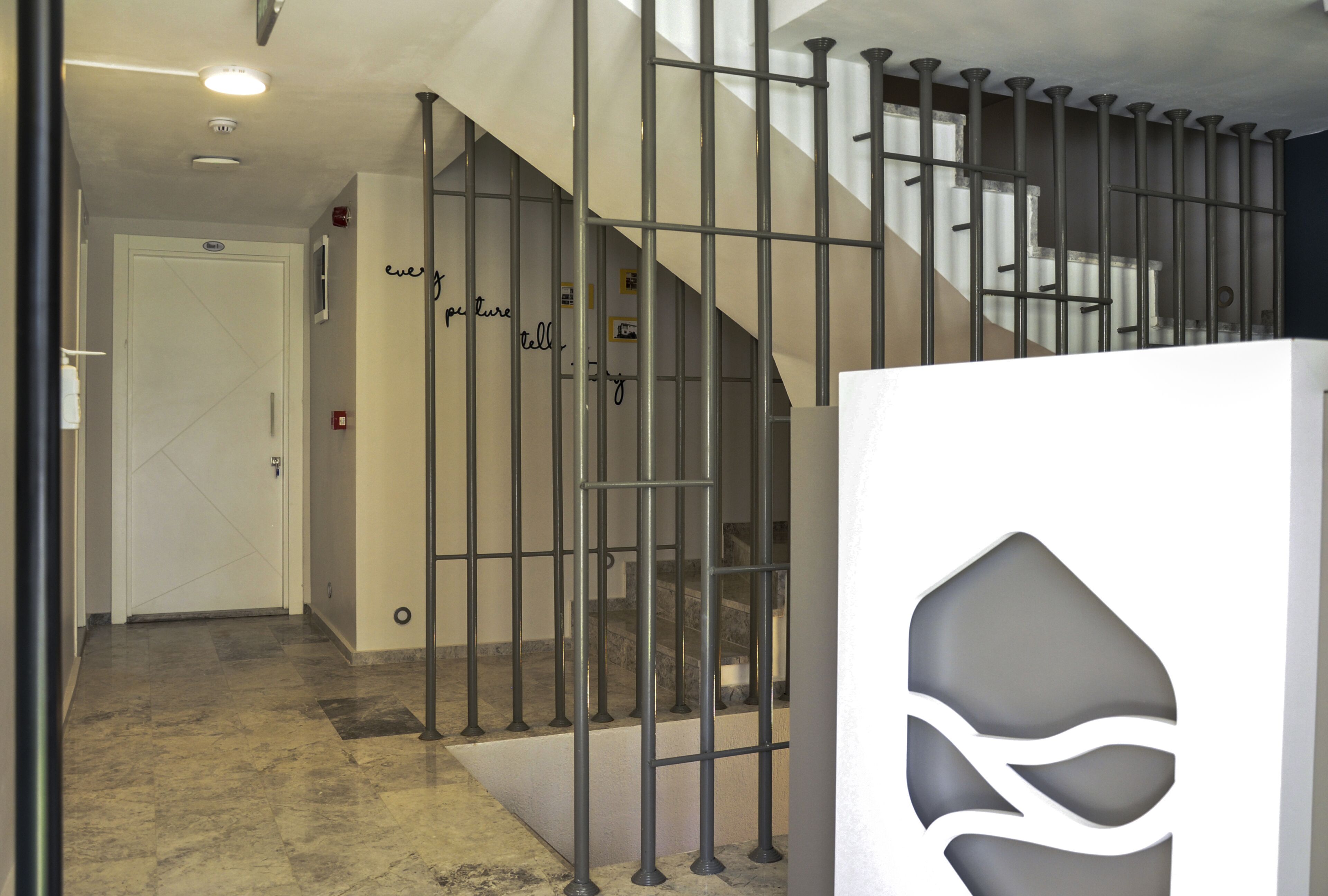 A staircase with metal railings and a decorative wall panel.