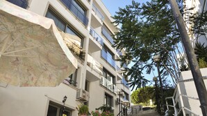 A multi-story building with balconies, a staircase, and outdoor seating. - Sahil Otel (Cesme)