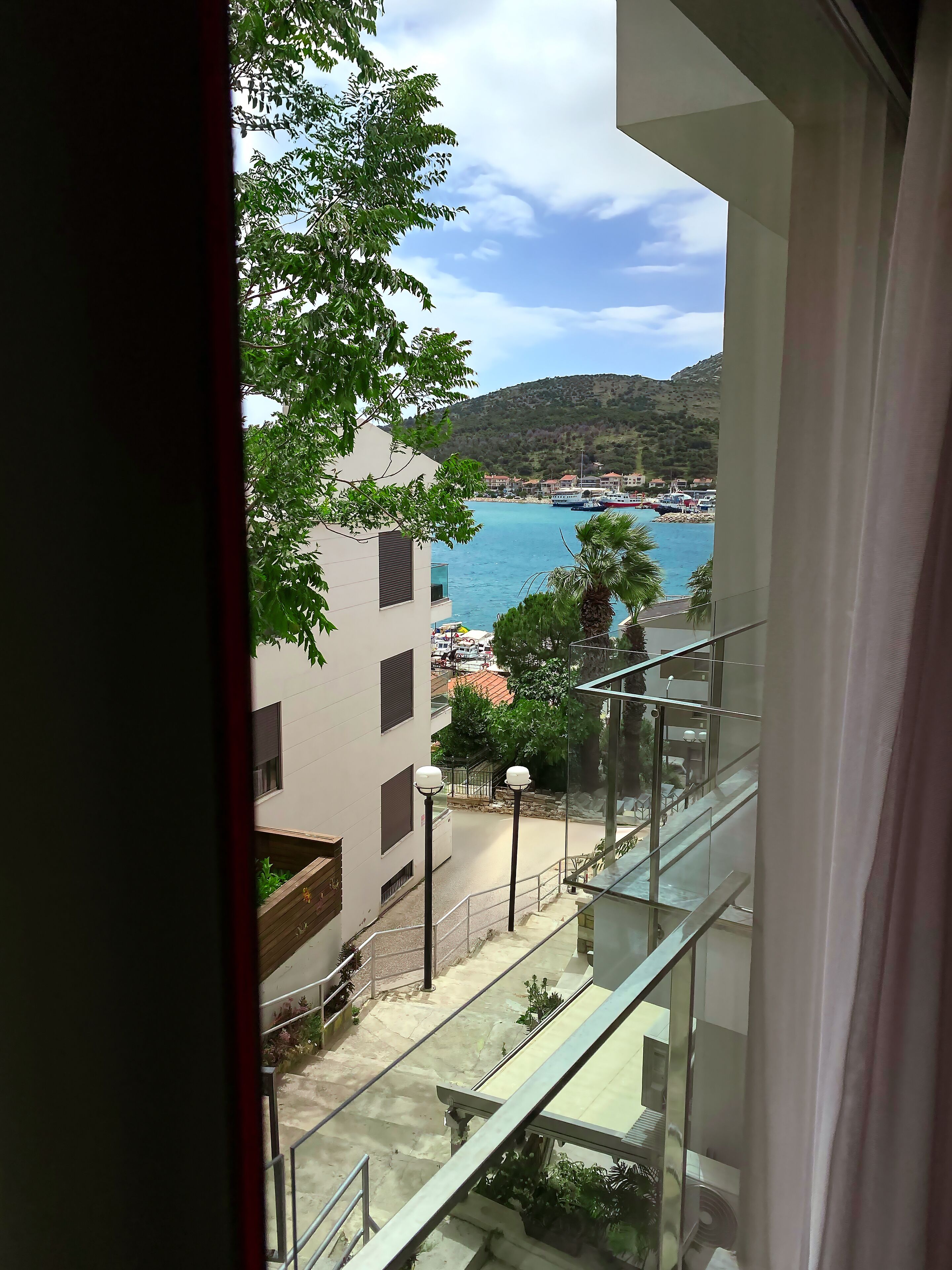 A view from a balcony overlooking a coastal area with buildings and boats.