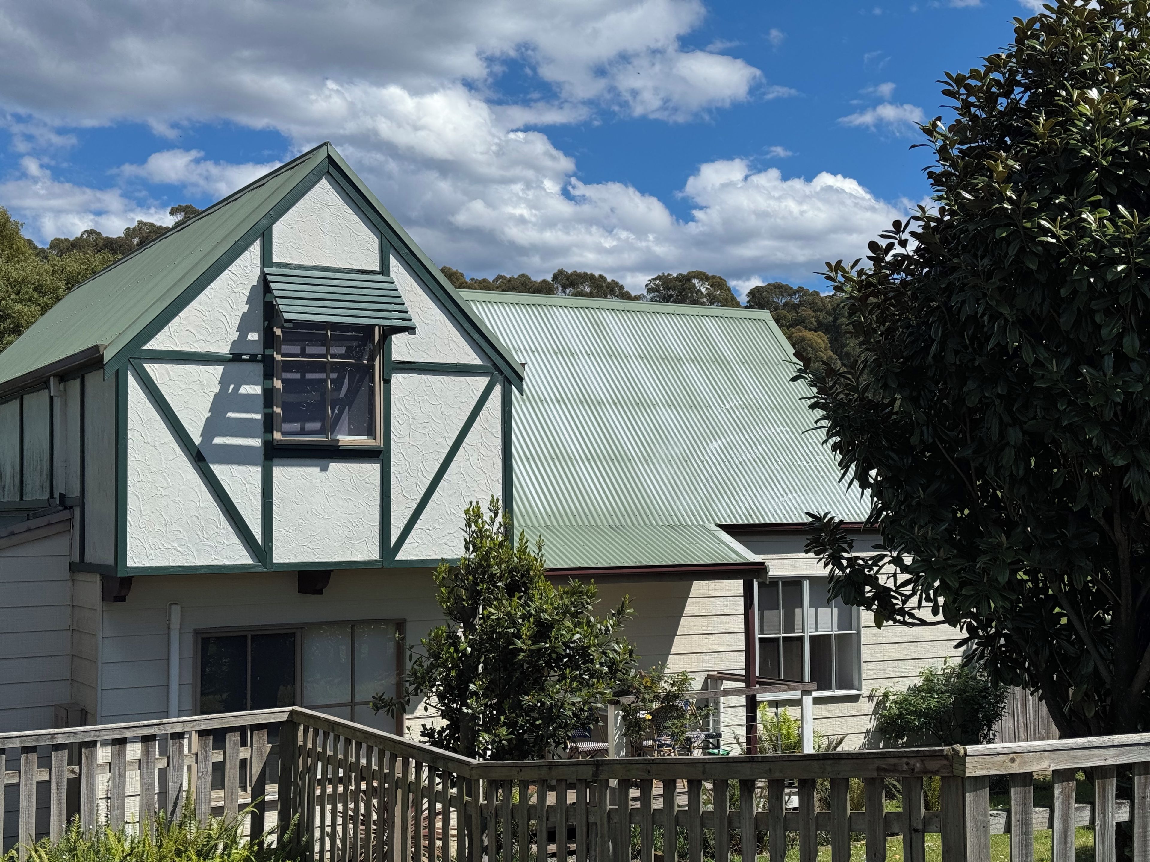 A two-story house with a gabled roof and a visible attic window.