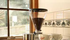 A coffee machine with a coffee grinder and two cups on a kitchen counter. - "Experience the ultimate retreat surrounded by the untouched beauty of nature.  (Erica)