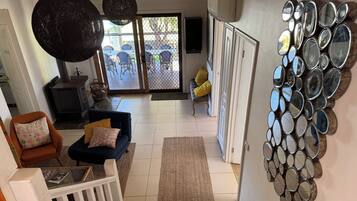 A staircase leading to a living area with a view of outdoor furniture and a wall with circular mirrors.