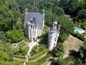 A large, castle-like building surrounded by lush greenery, with a swimming pool and manicured gardens. - Chateau de Coubloust (Vicq-sur-Nahon)