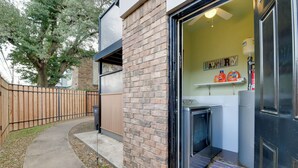 A laundry room with a brick wall, a washing machine, and a dryer. - Fort Worth Home w/ Patio: 5 Mi to Dtwn! (Fort Worth)