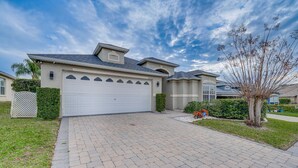 A residential house with a paved driveway, garage, and a well-maintained lawn. - 11 Mi to Disney: Family-Friendly Home in Davenport (Davenport)
