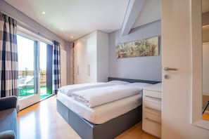 Un dormitorio moderno con una cama grande, un armario y vistas al exterior.