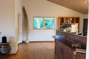 A kitchen with wooden cabinets, a countertop, and a window with a view of greenery. - Villa "Cerros Del Aguila" with Sea Views, Pool, Garden, and Wi-Fi (Mijas)