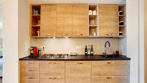 Een moderne keuken met houten kastjes, een gasfornuis, een spoelbak en een aanrecht.