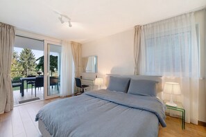 A bedroom with a bed, a desk, and a chair, a sliding glass door to a balcony, and a ceiling fan. - Apartment 'Panoramaresidence' with Mountain View, Garden & BBQ (Hafling)