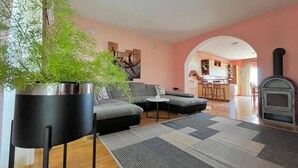 A living room with a sofa, a coffee table, a potted plant, and a fireplace. - Apartment Nico (Razanac)