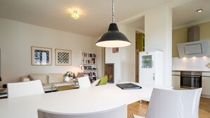 Et moderne køkken med hvide skabe, indbygget ovn og mikroovn.