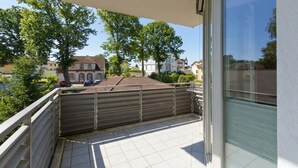 A balcony with a view of houses and trees. - Villa Estrelia, App. 6 (Heringsdorf)