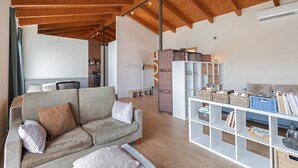 A living room with a sofa, a white shelving unit with baskets, and a wooden ceiling. - Studio 'Guest House - Loft Cim Apartments 3' with Mountain Views, Wi-Fi, and Air Conditioning (Olivella)