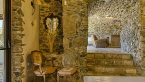 A stone-walled room with a fireplace, two chairs, a bench, and a small table. - Holiday Home "Mas Renart" with Mountain View, Pool, Wi-Fi, Garden & Terrace (Mollet de peralada)