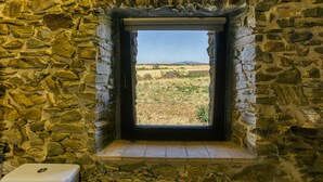 A stone-walled room with a window overlooking a field. - Holiday Home "Mas Renart" with Mountain View, Pool, Wi-Fi, Garden & Terrace (Mollet de peralada)