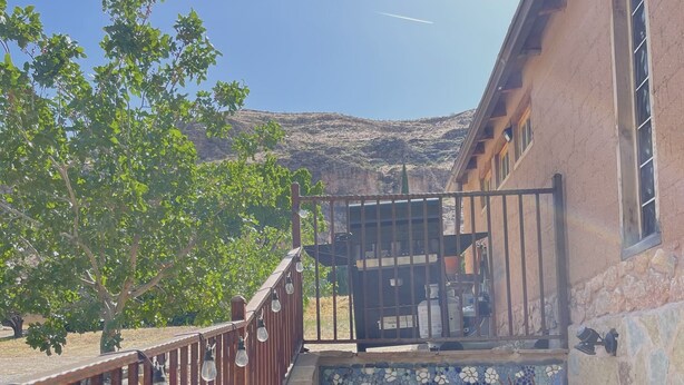 A stone staircase leading to a balcony with a view of a mountainous landscape.