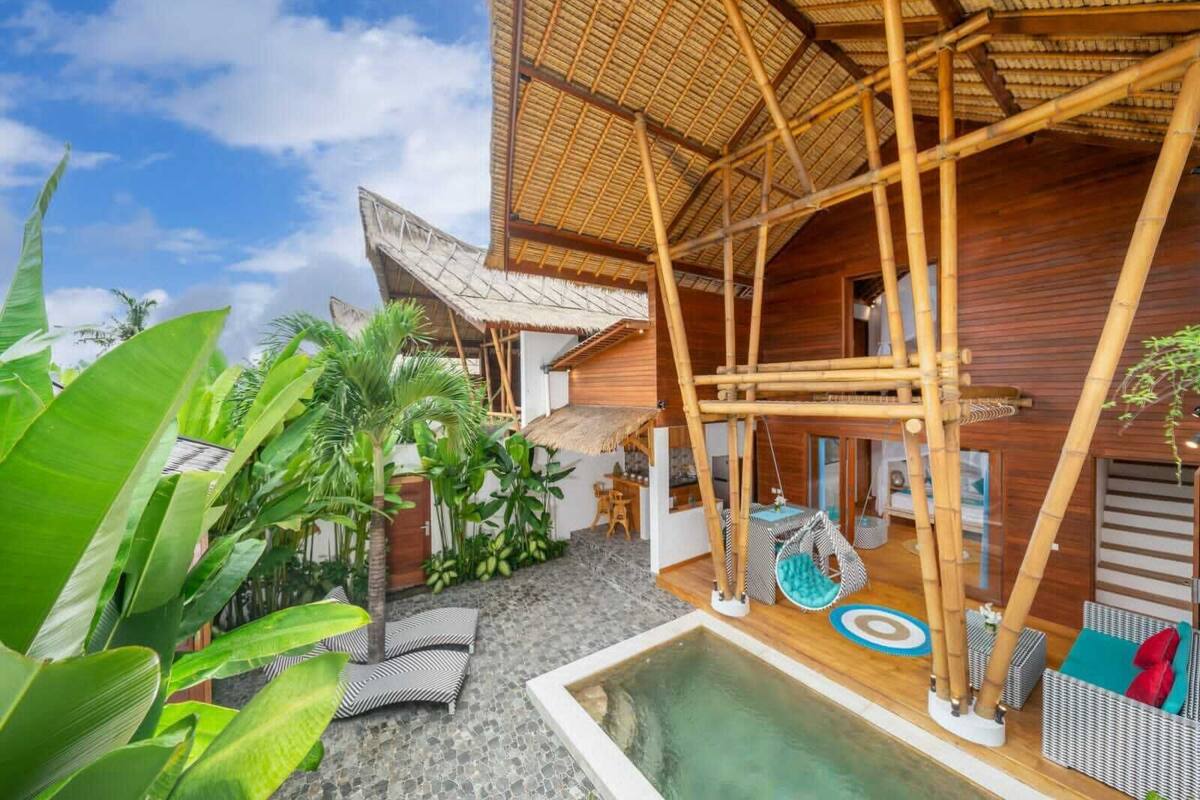 Une structure moderne en bambou dotée d’une piscine, d’un espace salon extérieur et d’une végétation luxuriante.