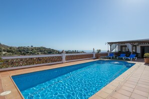 Ein Pool mit Meerblick, einer überdachten Sitzgelegenheit und einer umzäunten Terrasse.