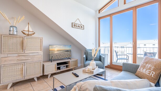Een moderne woonkamer met een televisie, bank en een balkon met uitzicht.