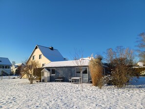 A house with a snow-covered yard, a visible chimney, and a small shed. - Cathrin's Boddenblick - View of Cathrin's Bodden (Wustrow)
