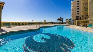 Ein Pool mit Spiralmuster, umgeben von Liegestühlen und einem Pavillon.