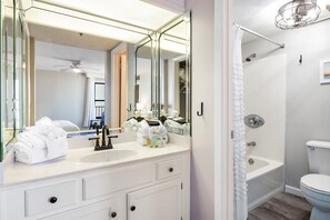 A bathroom with a white sink, mirror, and shower.