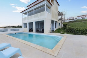 A two-story building with a swimming pool in the foreground.