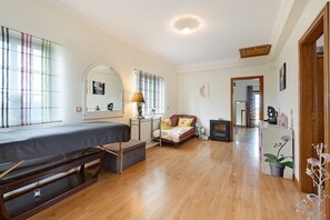 Una habitación con cama, escritorio, silla, lámpara y espejo.