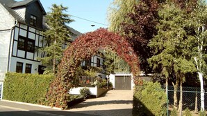 A traditional half-timbered building with a paved driveway leading to a garage.