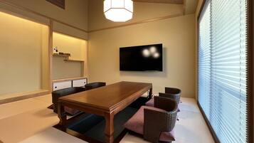 A traditional Japanese-style room with tatami flooring, a low wooden table, and woven chairs.