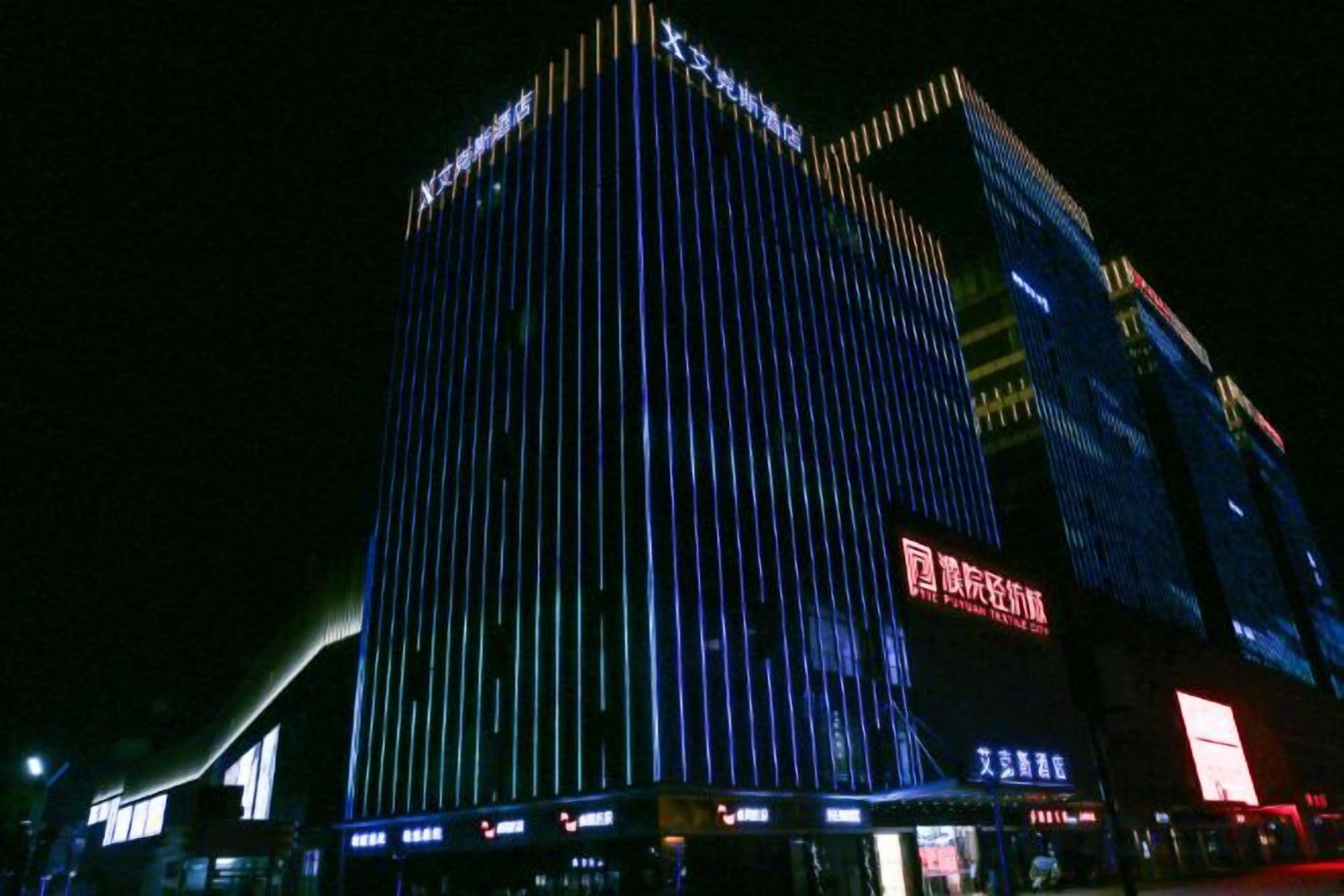 Un rascacielos con líneas verticales de iluminación.