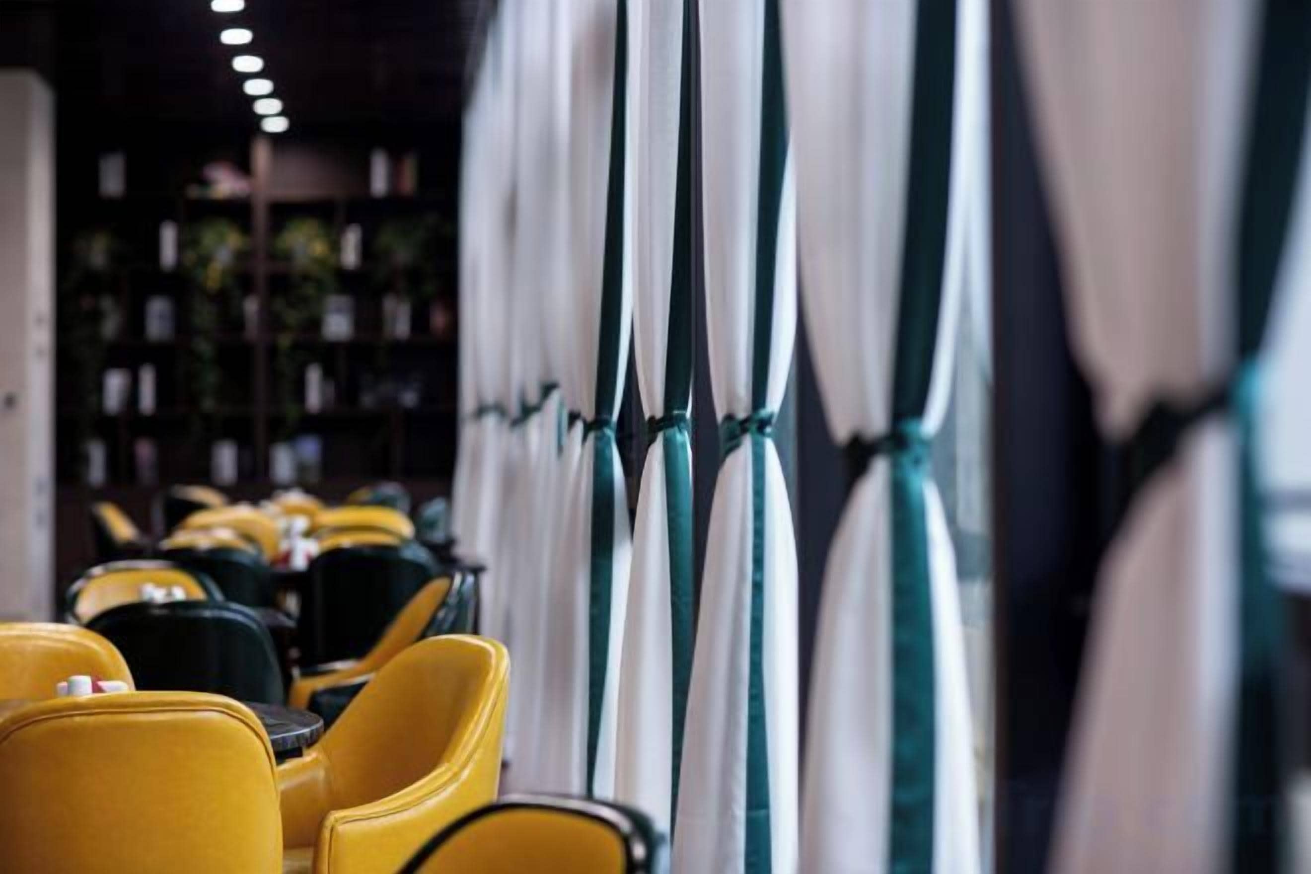 A row of yellow chairs and tables in a restaurant setting.