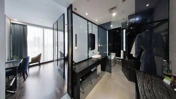 A modern hotel room with a large mirror, a desk, and a chair.