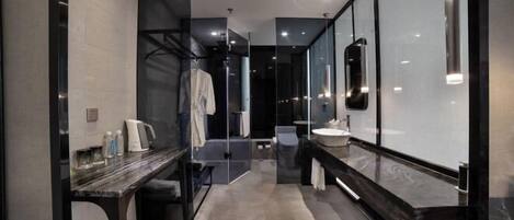 Une salle de bain moderne avec une douche à parois de verre, un comptoir en marbre et un grand miroir.