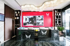 A hotel reception area with a digital display, marble flooring, and a modern design. - Puyuan X Hotel (Tongxiang)