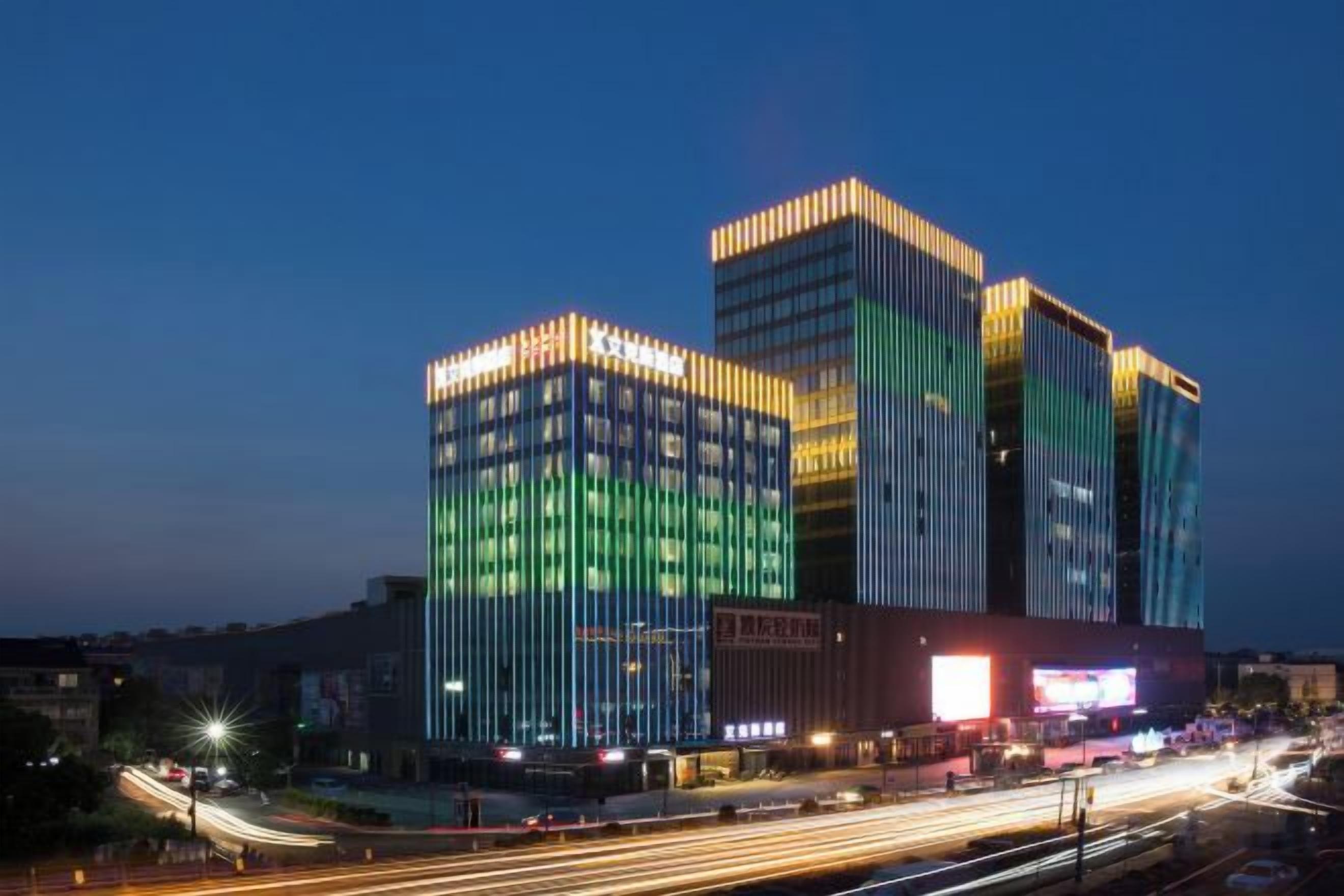 A multi-story building with illuminated windows and a prominent entrance.