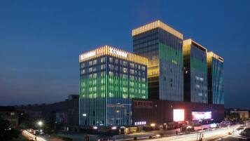 A multi-story building with illuminated windows and a prominent entrance.