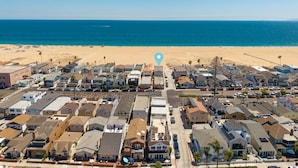 Zona residencial costera con casas, una playa y cielo despejado.