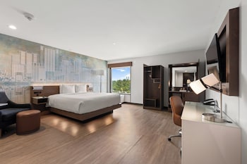 A balcony with a view of a cityscape, including buildings and a parking area. at Cambria Hotel Orlando Universal Blvd
