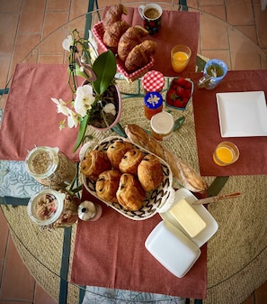 A breakfast setup with pastries, fruits, and condiments on a woven mat. - Bastide Beaudinard (Aubagne)