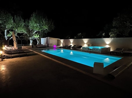 Una piscina al aire libre de temporada, sombrillas