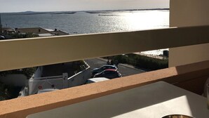 A balcony with a view of the sea and parked cars below. - 2* Apt with AC and Pets Allowed in Balaruc-les-Bains (Balaruc-les-Bains)